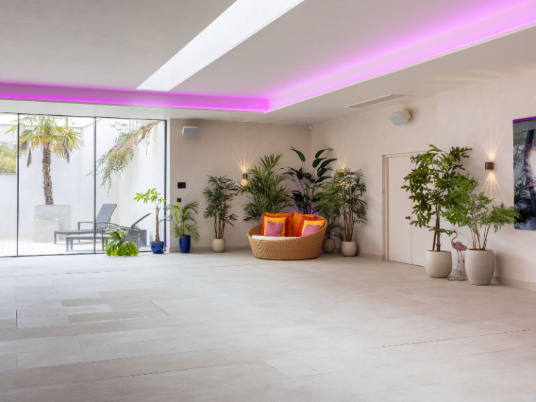 Soft purple ceiling lighting in a luxury, pool room setting.