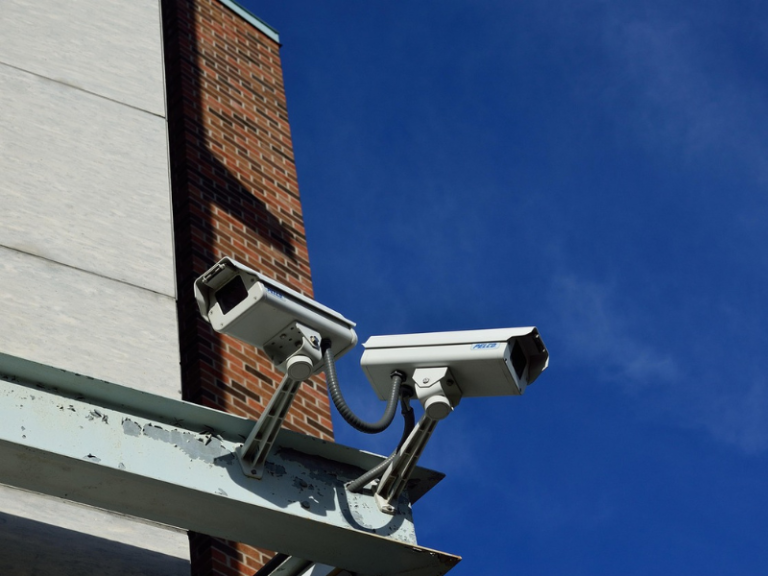 Two CCTV Cameras operating above a building.